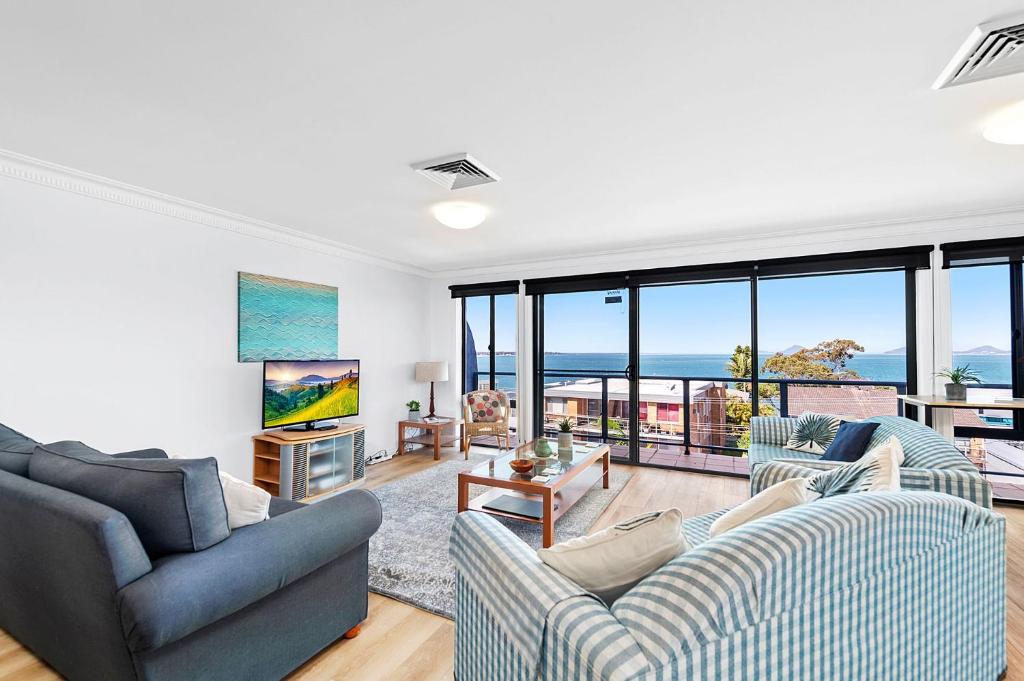 a living room with two couches and a view of the ocean at Peninsula Waters Unit 14 Soldiers Point Road 2 in Soldiers Point