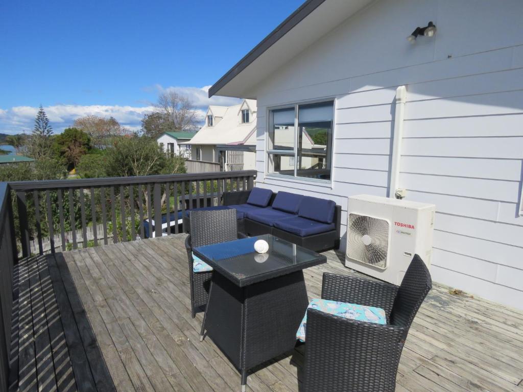 a patio with a table and chairs on a deck at Hihi Getaway in Mangonui