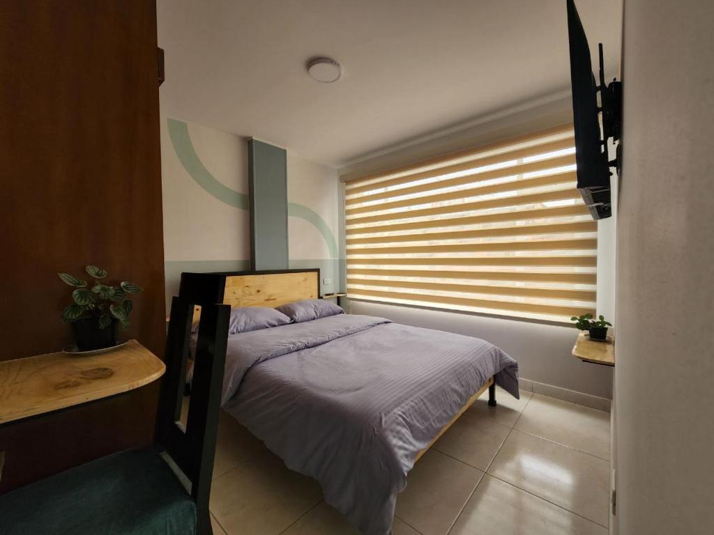 una camera con letto e finestra con persiane di Habitación 10 min Aeropuerto C a Bogotá
