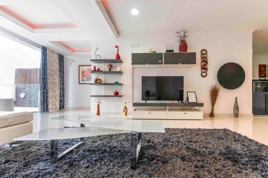a living room with a glass table and a tv at Oceanfront 3BR Penthouse Luxury & Views in Sliema in Sliema