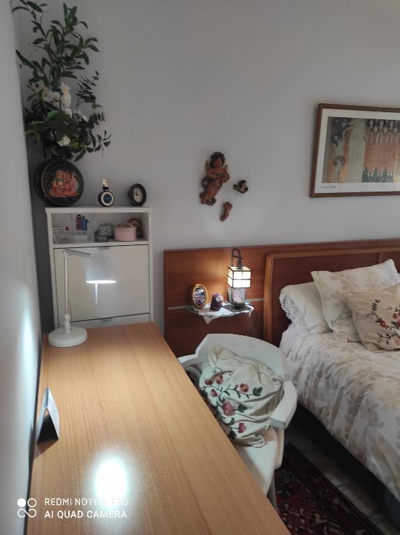 Schlafzimmer mit einem Bett und einem Holztisch in der Unterkunft Maravilloso apartamento in San Sebastián de los Reyes