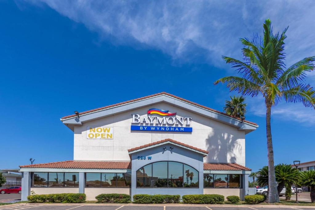 a bryant open sign on a building with a palm tree at Baymont by Wyndham McAllen Pharr in McAllen