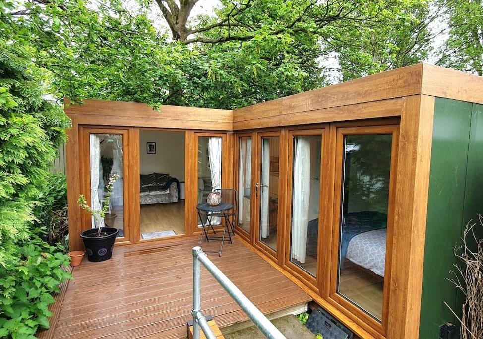 a wooden cabin with a deck with a bed in it at Private Self Contained Annex/Cabin in Birmingham
