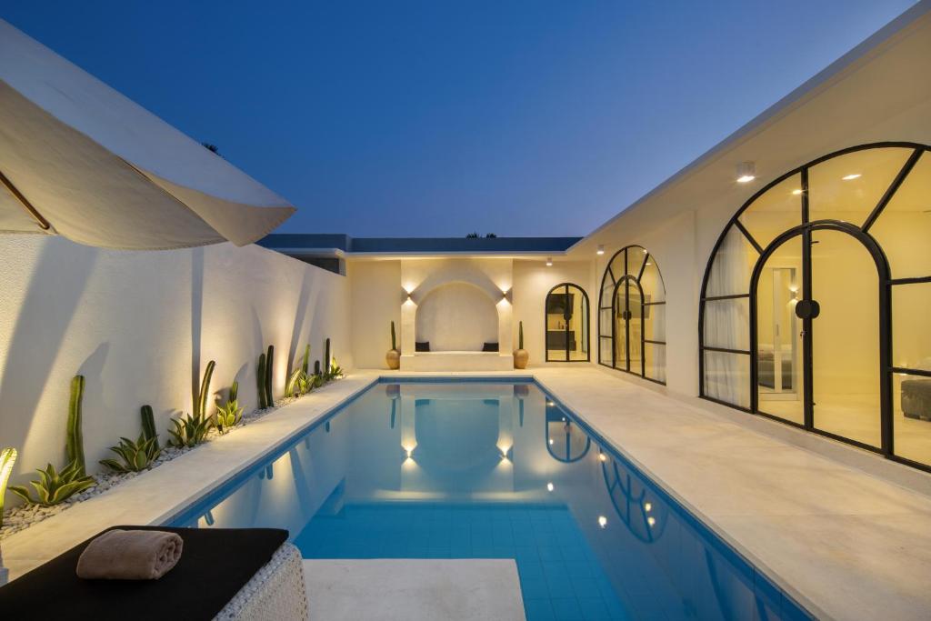 a swimming pool in a home with a lit up house at The Grand Daha Luxury Villas in Seminyak