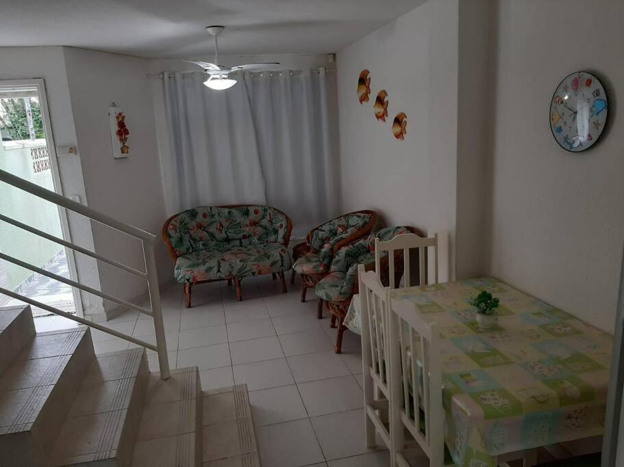馬蒂尼奧斯的住宿－Sobrado confortável a uma quadra do mar.，客厅设有两把椅子、一张桌子和楼梯