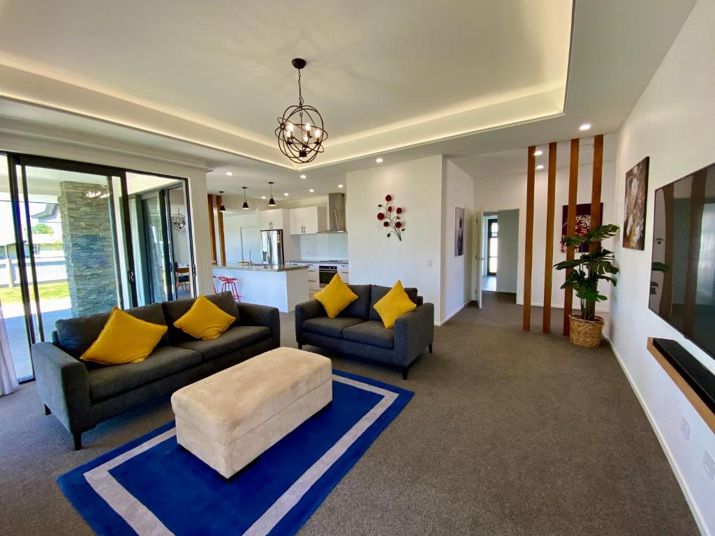 a living room with two couches and yellow pillows at Style, Functional with Space in Twizel