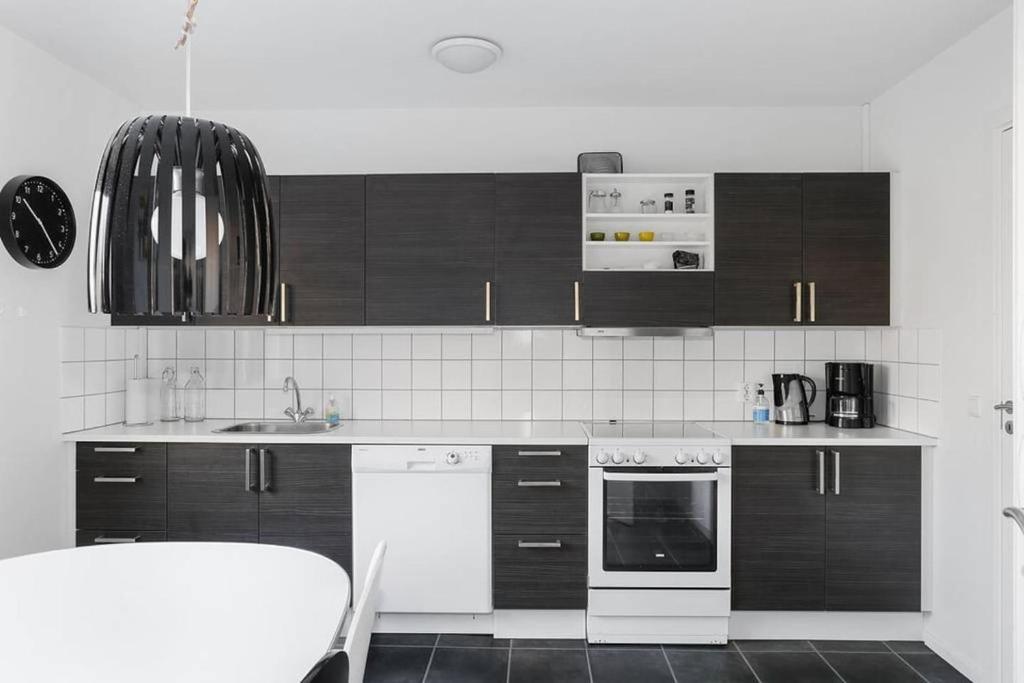 a kitchen with black cabinets and white appliances at Fint boende nära Isaberg Mountain Resort in Grimsås
