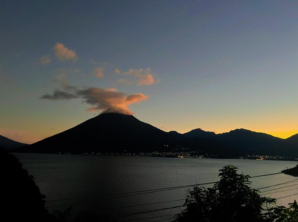 a mountain with a cloud over a body of water at Hotel Villa Tzankujil in San Marcos La Laguna