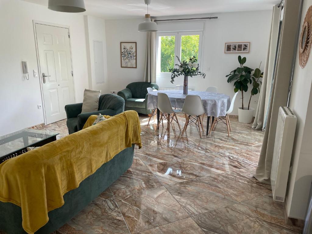 a living room with a table and a yellow towel on the floor at L' appart de Chantal in Lherm