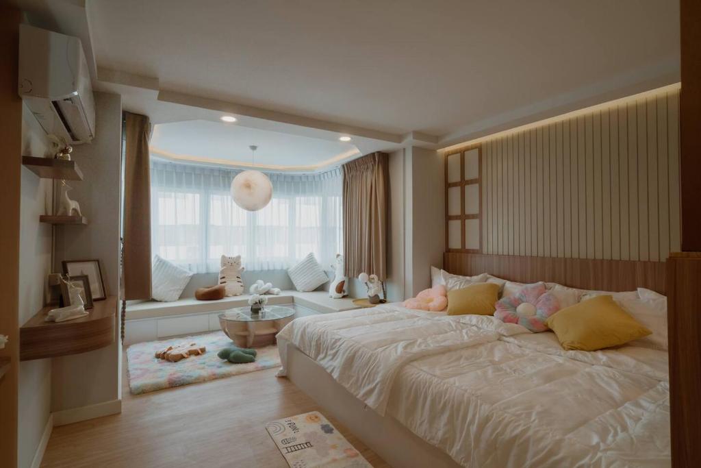 チェンマイにあるMini jung cozyの大きなベッドと窓のある寝室