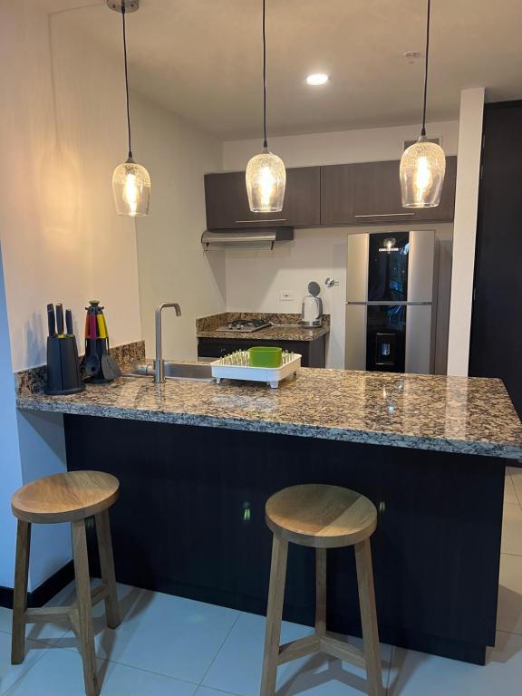 a kitchen with two bar stools and a counter top at Towers Confort in Rionegro