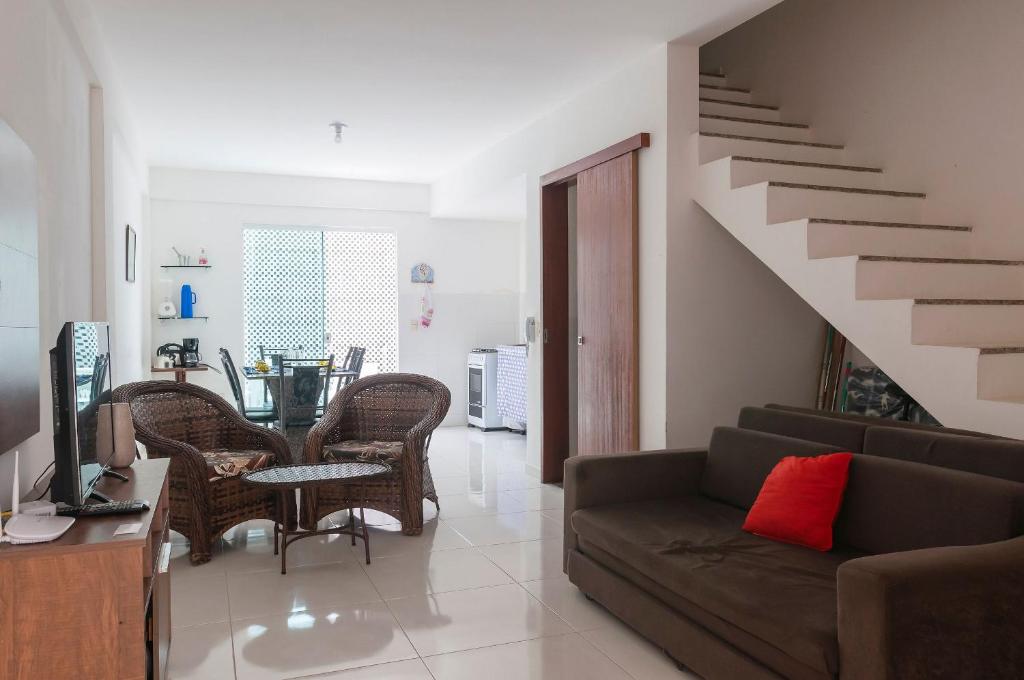 a living room with a couch and a staircase at Sobrado a 300m da praia de Ilhéus VCM005 in Ilhéus
