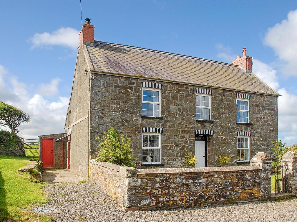 an old stone house with a red door at South Nolton Farmhouse-qc1265 in Nolton