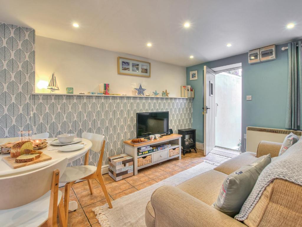 a living room with a couch and a table at Daffodil Cottage in Laugharne