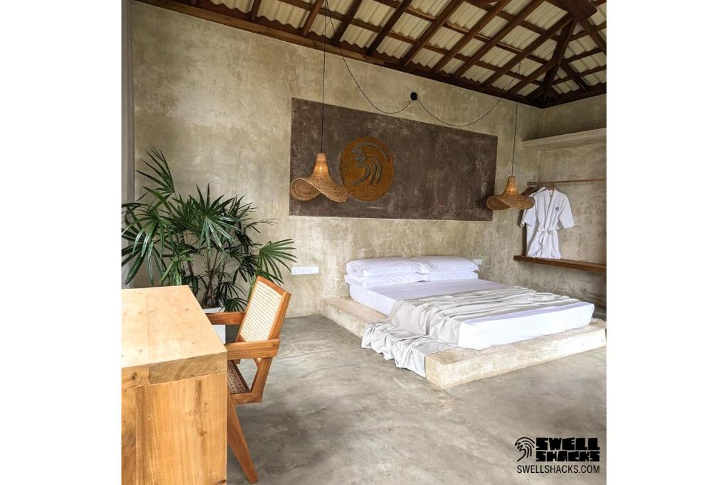 - une chambre avec un lit et une table dans l'établissement Swell Shacks, à Matara