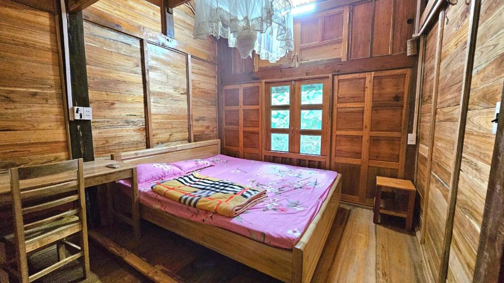 a small room with a bed in a wooden room at Ha Giang Faithien Homestay in Ha Giang