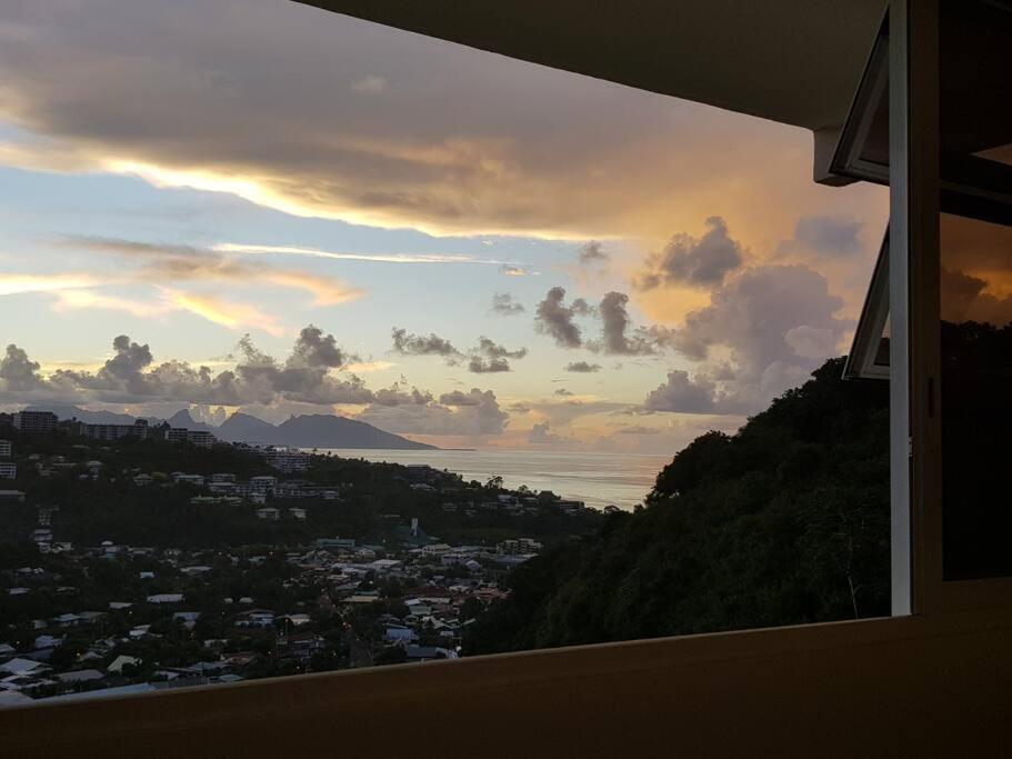 a view of a city from a window at sunset at PAPEETE - Kahaia Apartment in Papeete