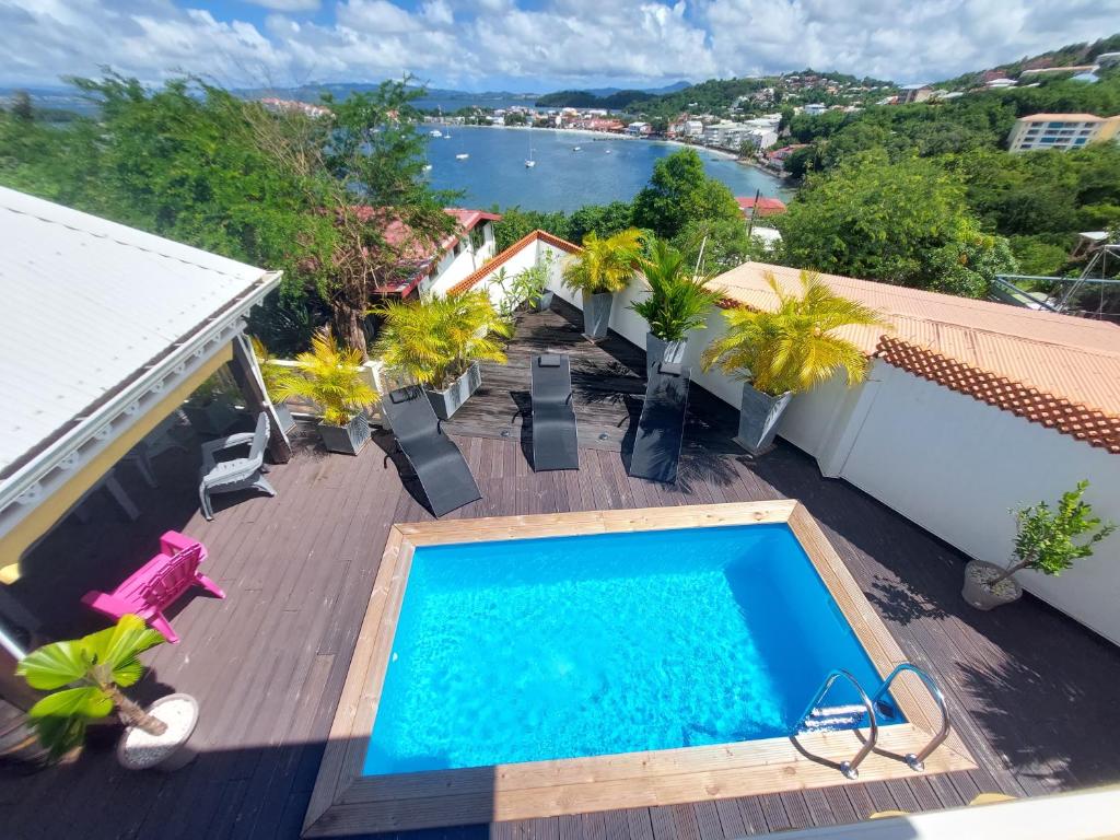 a swimming pool on a deck with a view of the water at Villa Nautilia , vue mer, proche plage in Les Trois-Îlets
