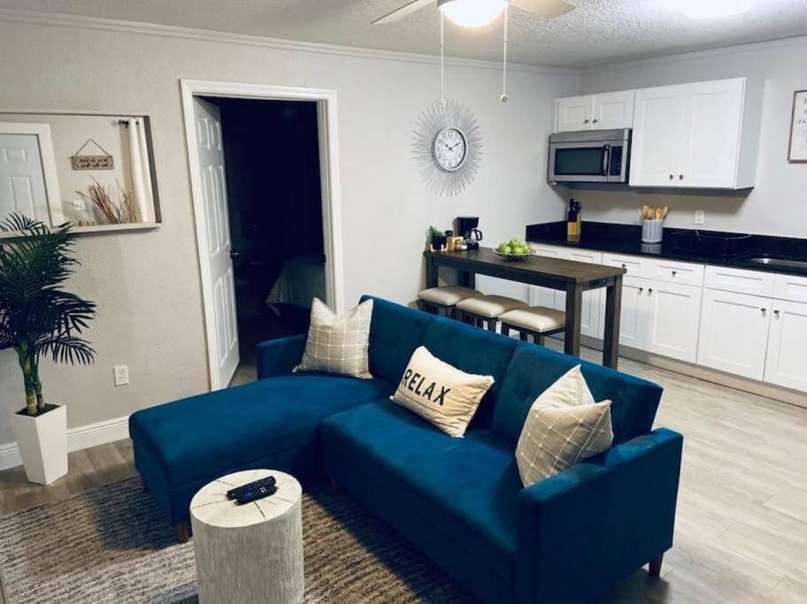 Una sala de estar con un sofá azul y una cocina. en 1 BD Apt close to Disney/Universal/Shopping/Dining, en Kissimmee