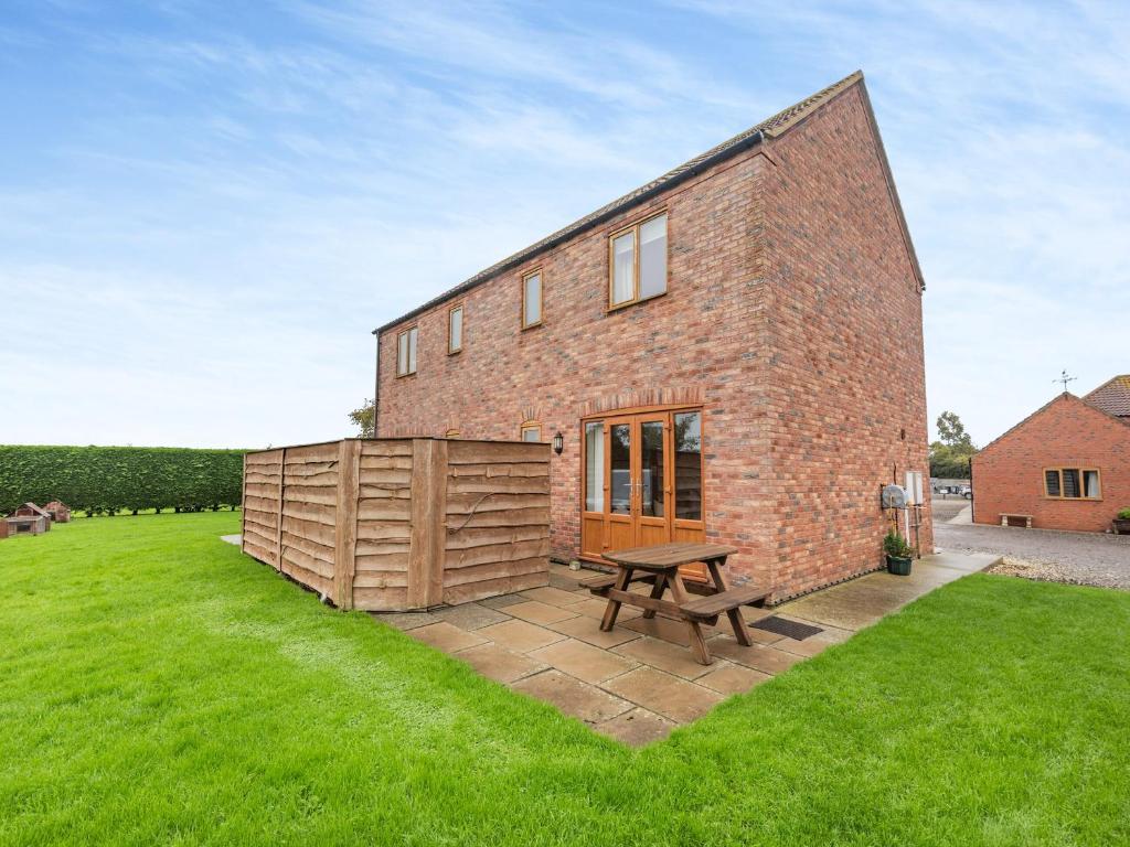 a brick house with a picnic table in front of it at Lake View 1 - Uk45577 in Maltby le Marsh