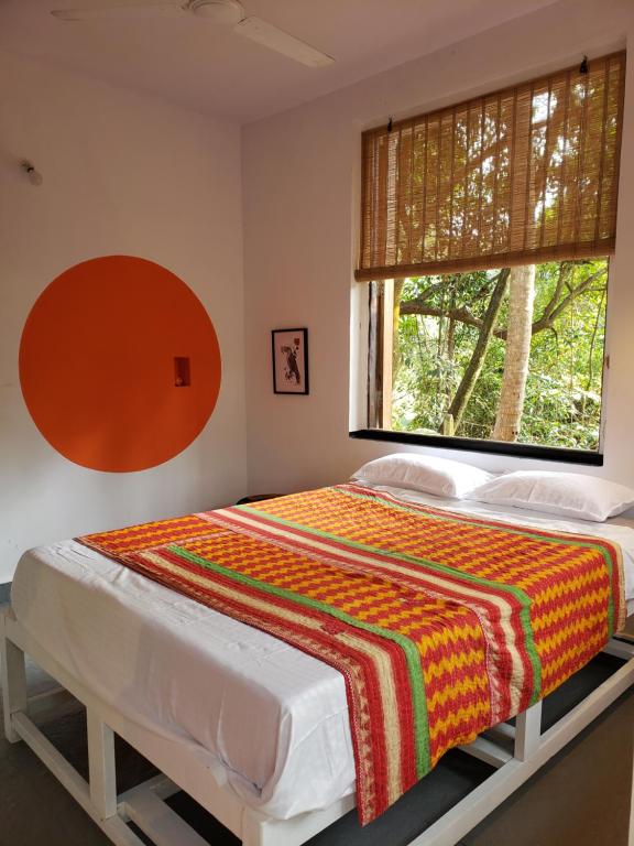 a bedroom with a large bed with a window at Adi Shakti Guesthouse in Querim