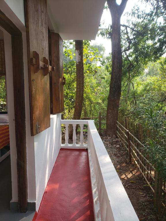 a red walkway leading to a house with trees at Laxmi Happy Home in Querim Goa in Querim