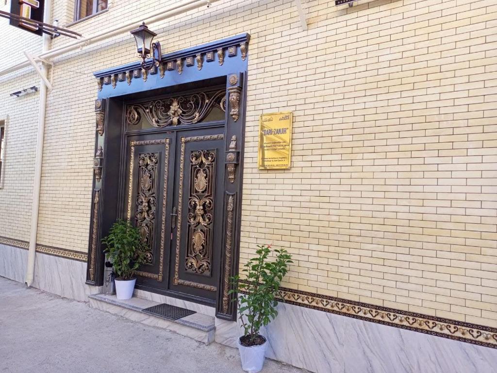a black door on the side of a brick building at Dari Zanjir in Samarkand