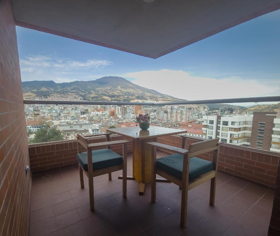 una mesa y sillas en un balcón con vistas en Apartamento panorámico de lujo en el Centro de Pasto, en Pasto