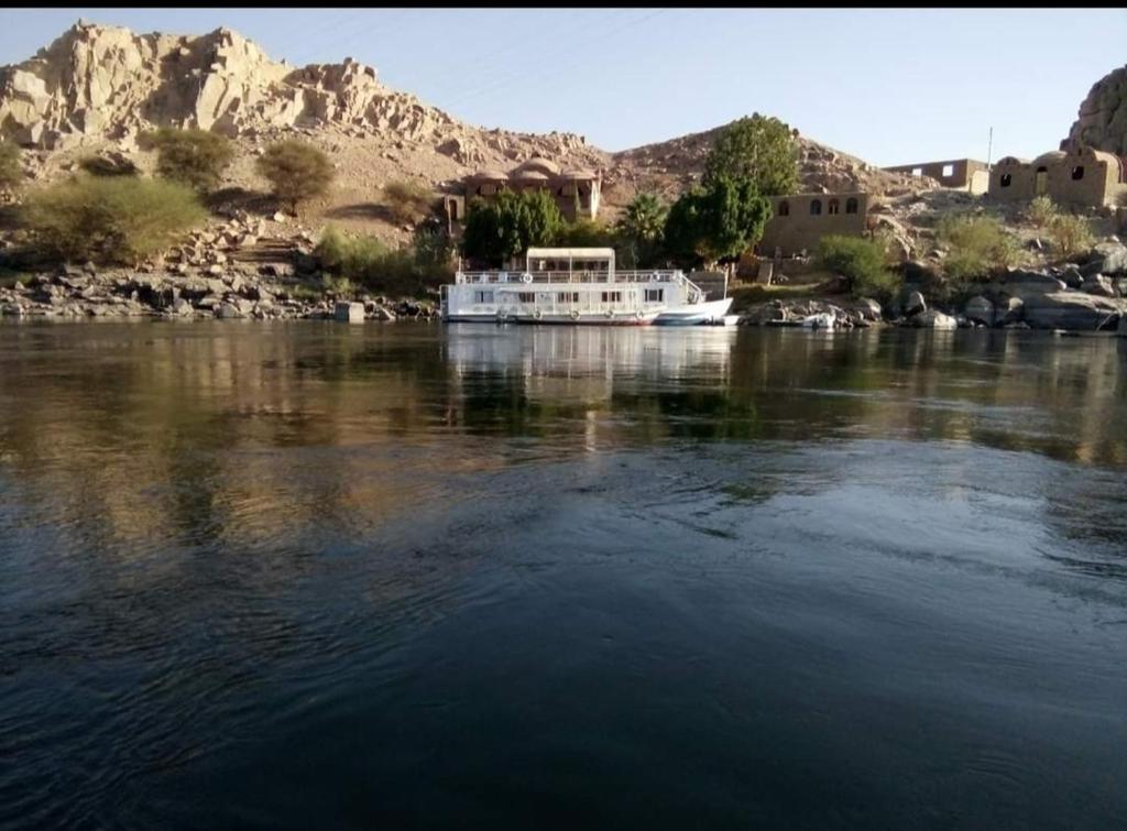 a boat on a river with mountains in the background at جزيره سهيل in Cairo