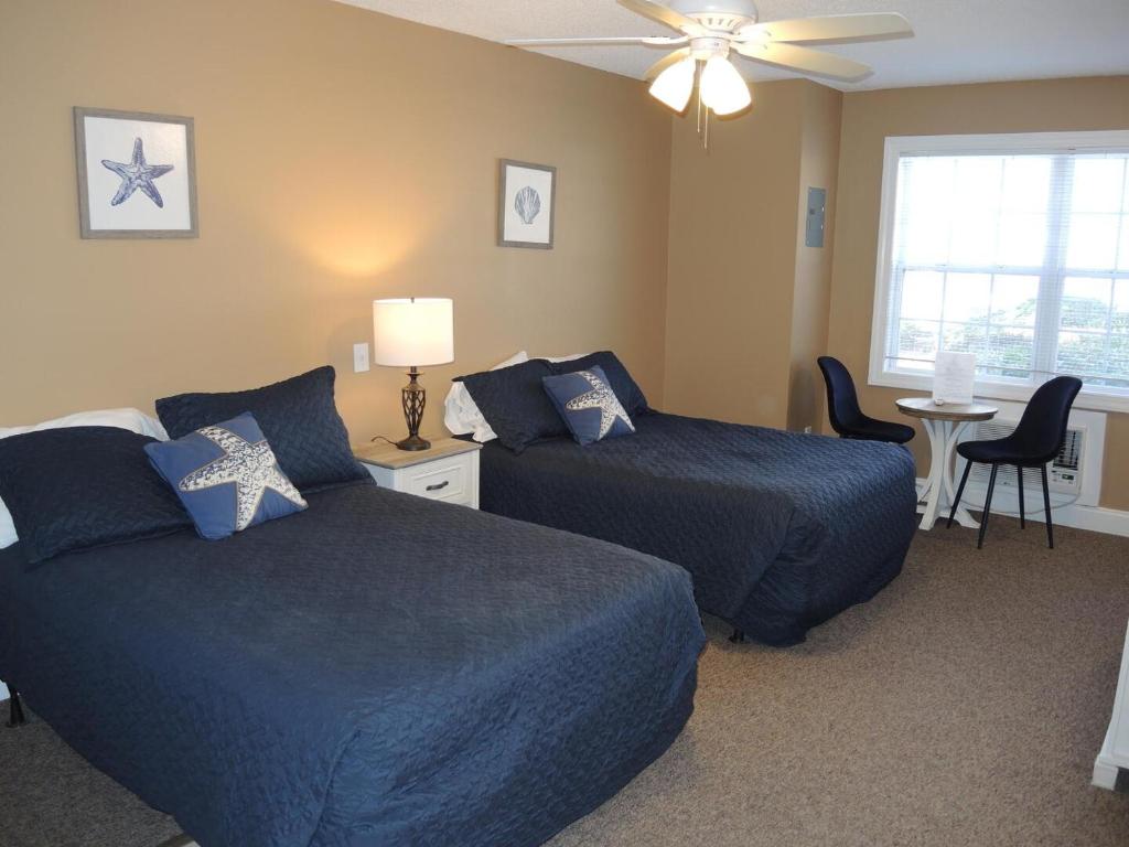 a hotel room with two beds and a table at Brunswick Plantation Studio Home 1301L in Calabash
