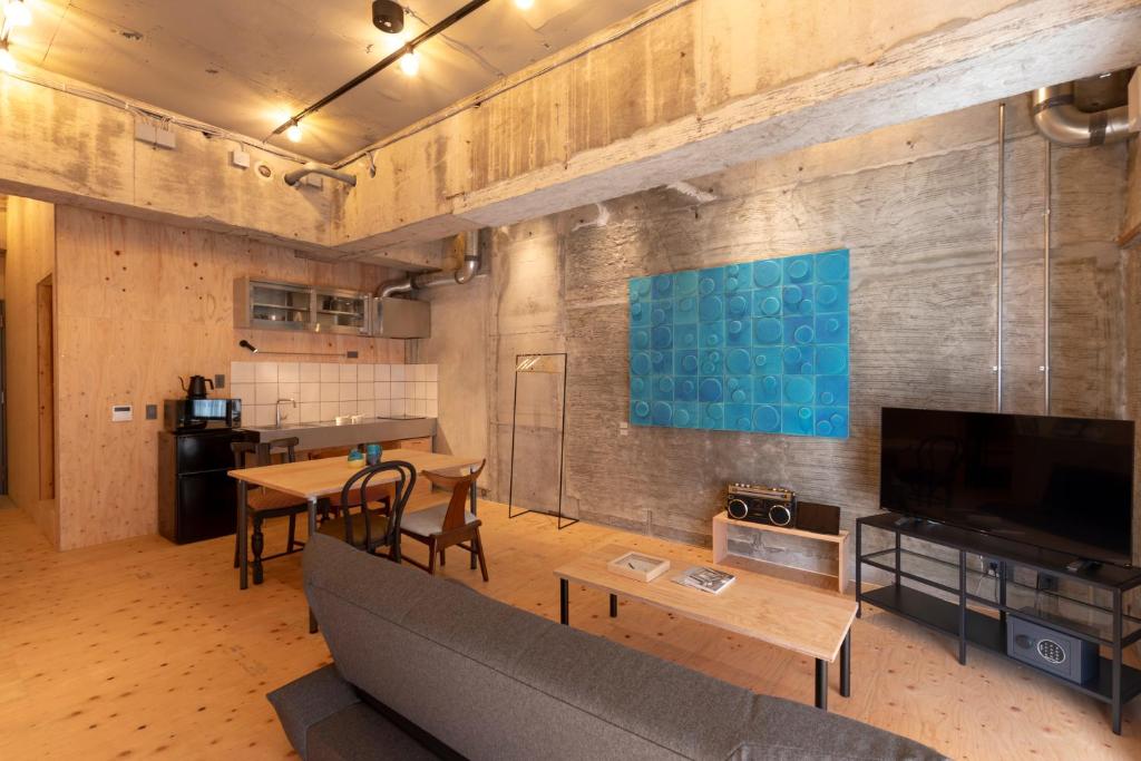 ein Wohnzimmer mit einem Sofa und einem Tisch in der Unterkunft HAJIMARI Beppu in Beppu