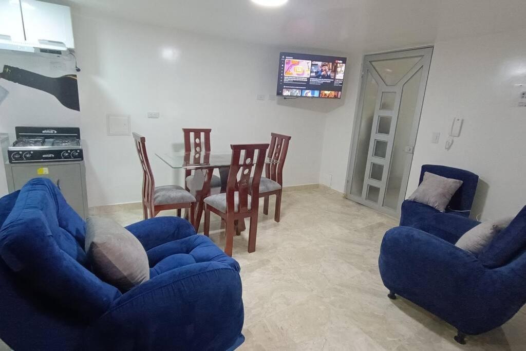 uma sala de estar com duas cadeiras azuis e uma mesa em Apartamento Nuevo y Central em Santa Rosa de Viterbo