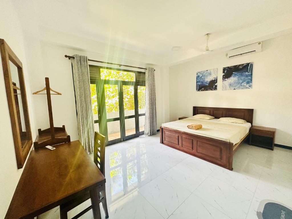 een slaapkamer met een bed en een kruis aan de muur bij Little Paradise in Weligama