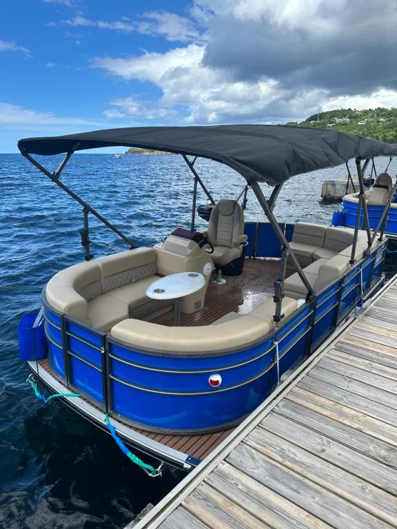 a blue boat tied up to a dock at RELAX BOAT BATEAU SANS PERMIS in Bouillante