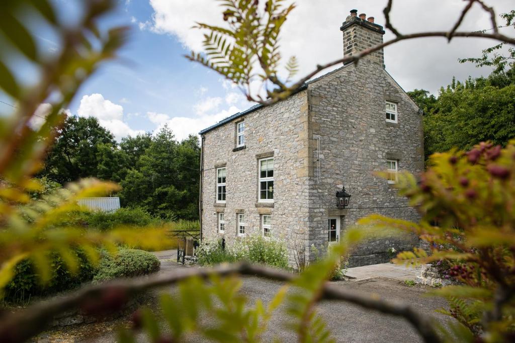 un antiguo edificio de ladrillo con chimenea en la parte superior en Candle House By Muse Escapes en Castleton