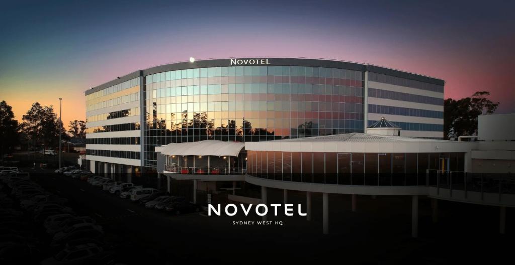 un bâtiment avec un panneau sur son côté dans l'établissement Novotel Sydney West HQ, à Rooty Hill