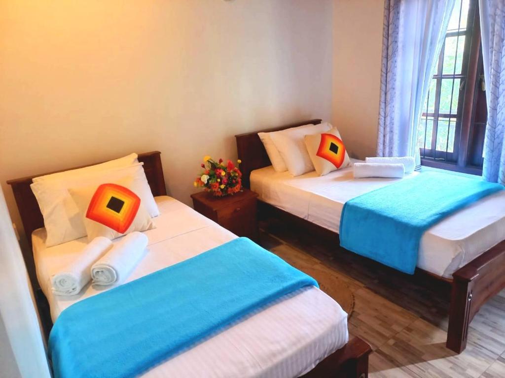 a room with two beds and a window at Dinu Lanka Resort in Katunayake
