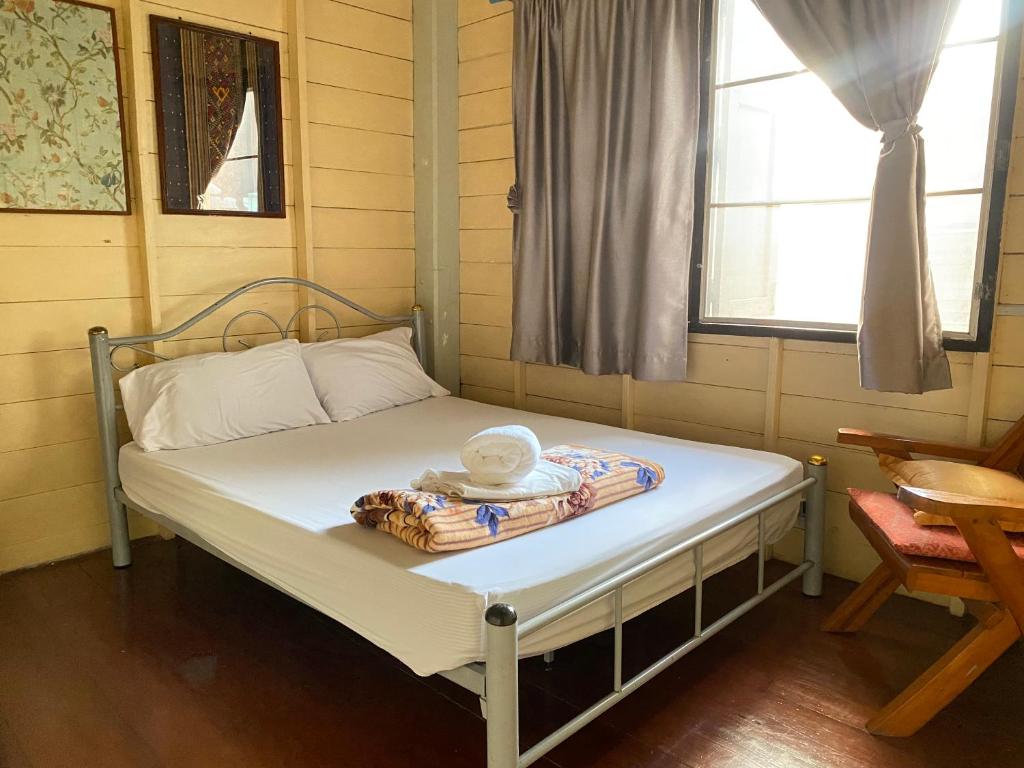 a small bed in a room with a window at Baan Jaidee Guesthouse in Trat