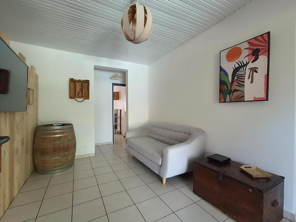 a living room with a couch and a barrel at Villa Korail Caraibes in Les Trois-Îlets