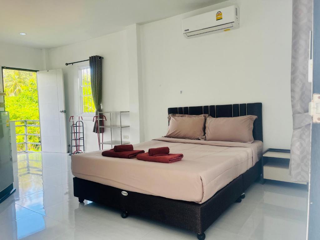 una camera da letto con un grande letto con cuscini rossi di Rest Mind House a Ban Lum Fuang