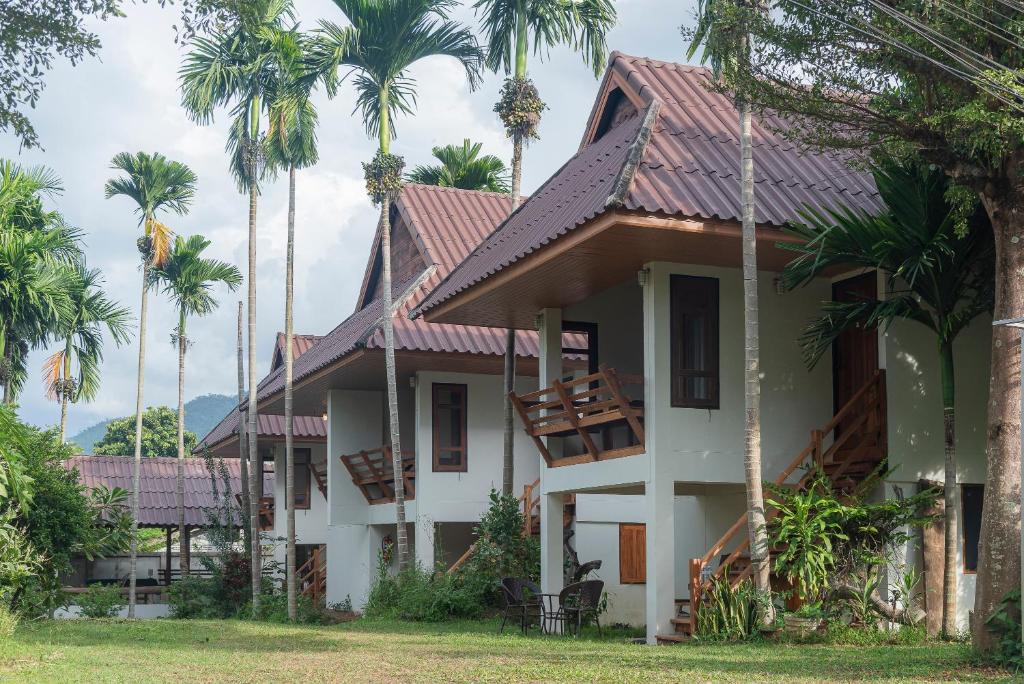 una casa con palmeras en el fondo en Betel Palm Village - Casa Retreat en Pai