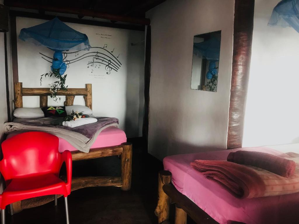 a bedroom with a red chair and a bed at The paulwood home cabin in Nuwara Eliya
