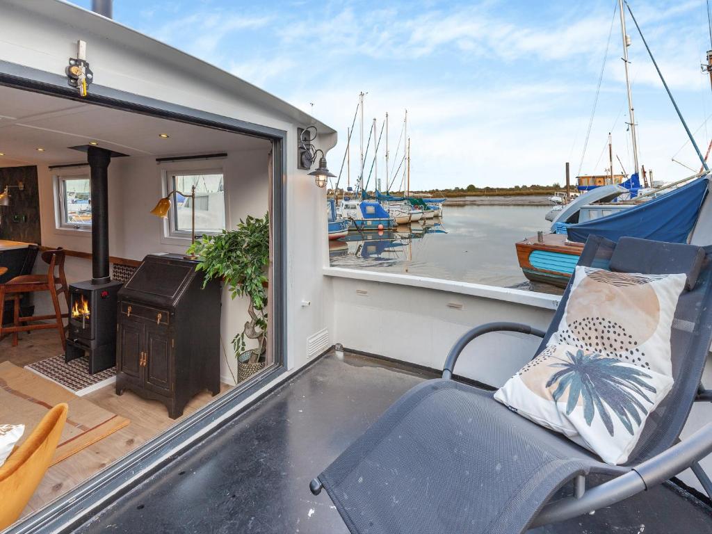 a porch with a chair and a grill and boats at Cos I Can - Uk45570 in Maldon