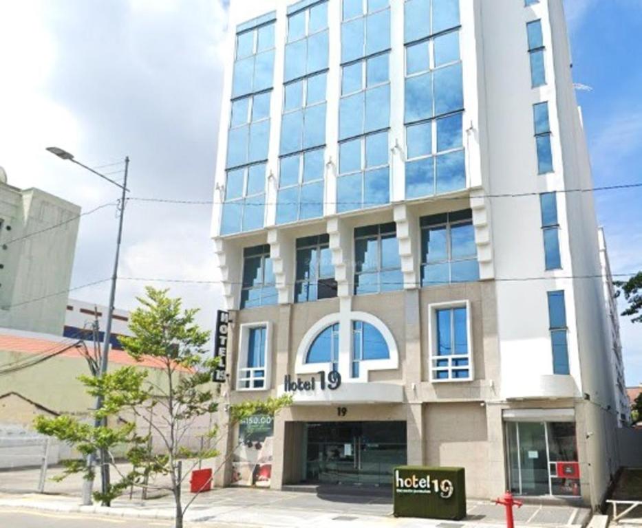 een groot wit gebouw met veel ramen bij Hotel 19, Penang in George Town