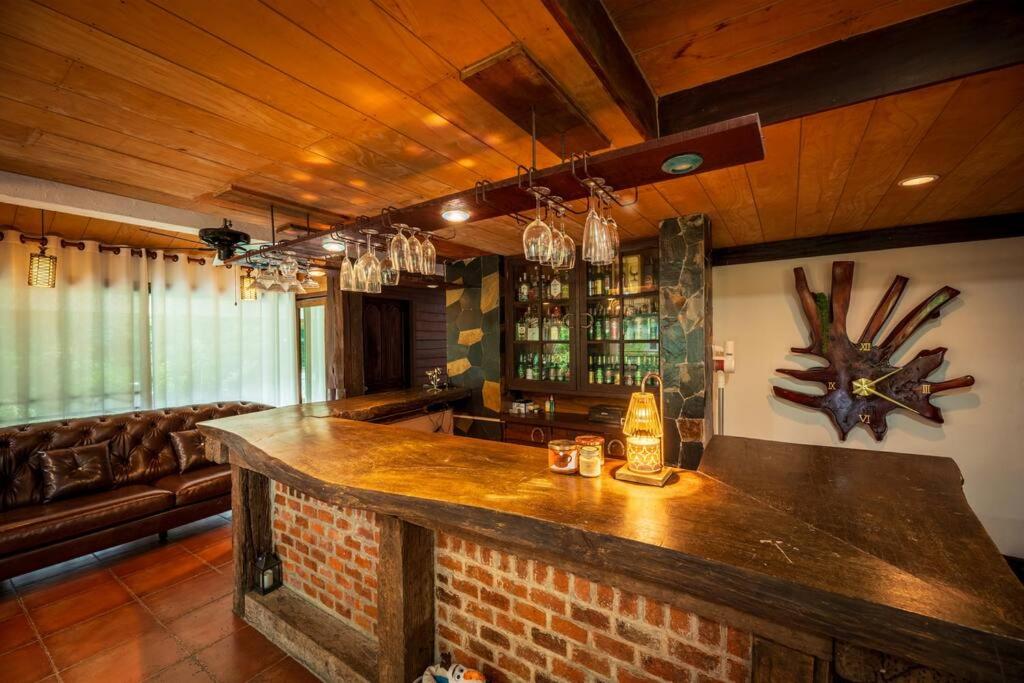- un bar dans une pièce avec un canapé dans l'établissement Khao Yai Log House, à Pak Chong