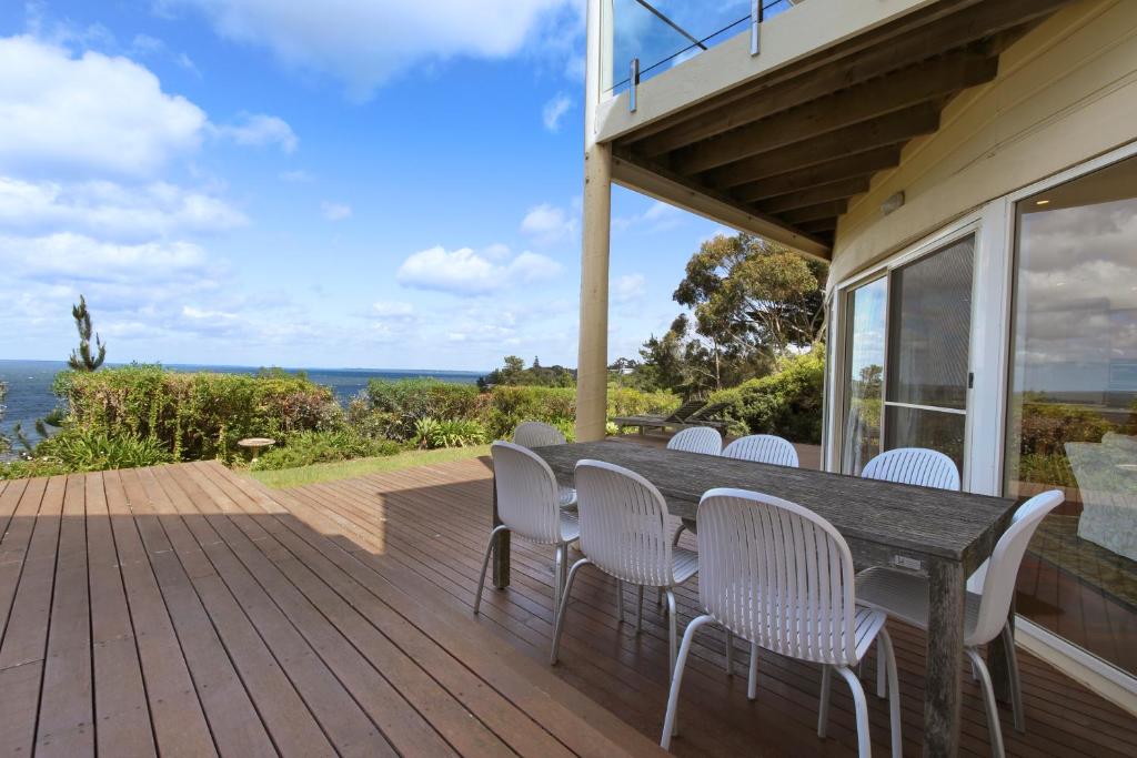 a wooden deck with a table and chairs on a house at Aegina - Scenic Lakeside Family Retreat in Metung