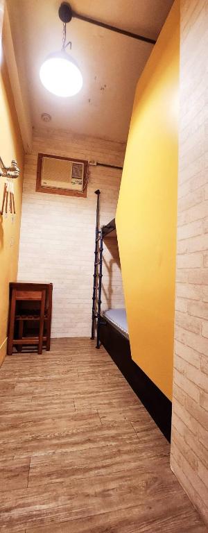 a room with bunk beds and a yellow wall at Hive Bed and Backpacker蜂巢膠囊旅店 in Hualien City