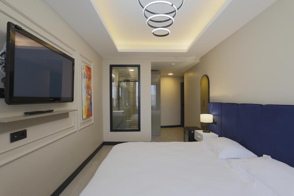 a bedroom with a large bed and a flat screen tv at Ravello Suites Taksim in Istanbul