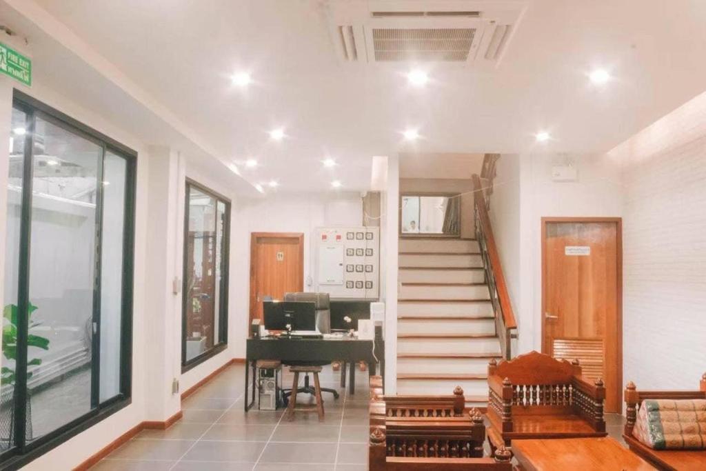 a living room with a staircase and a piano at Jira19Hostel in Bangkok