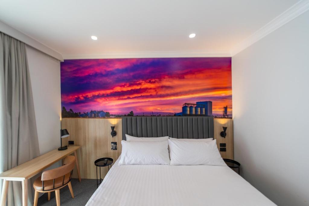 um quarto com uma cama e um quadro na parede em Royal Hotel-Motel em Moree